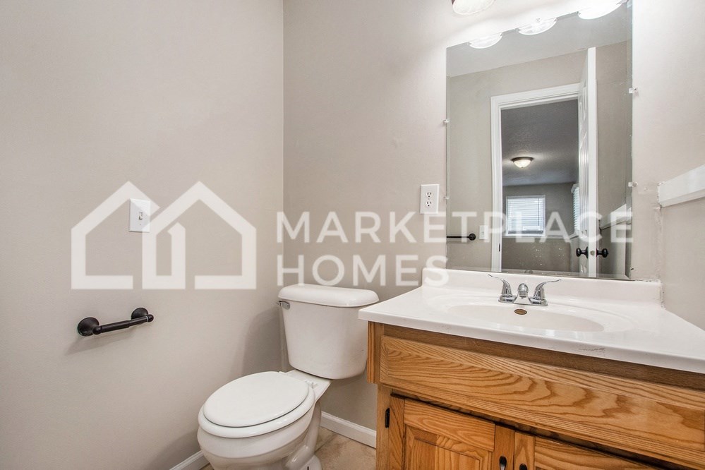 an image of a bathroom with a sink toilet and mirror