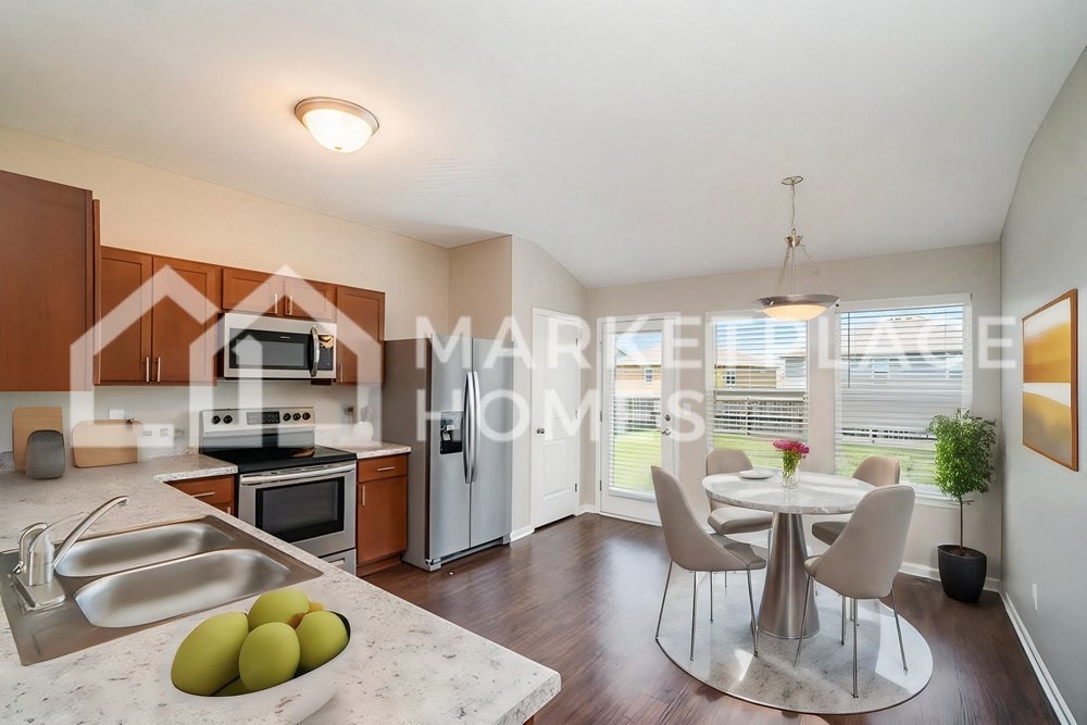 a studio apartment with a kitchen and a table and chairs