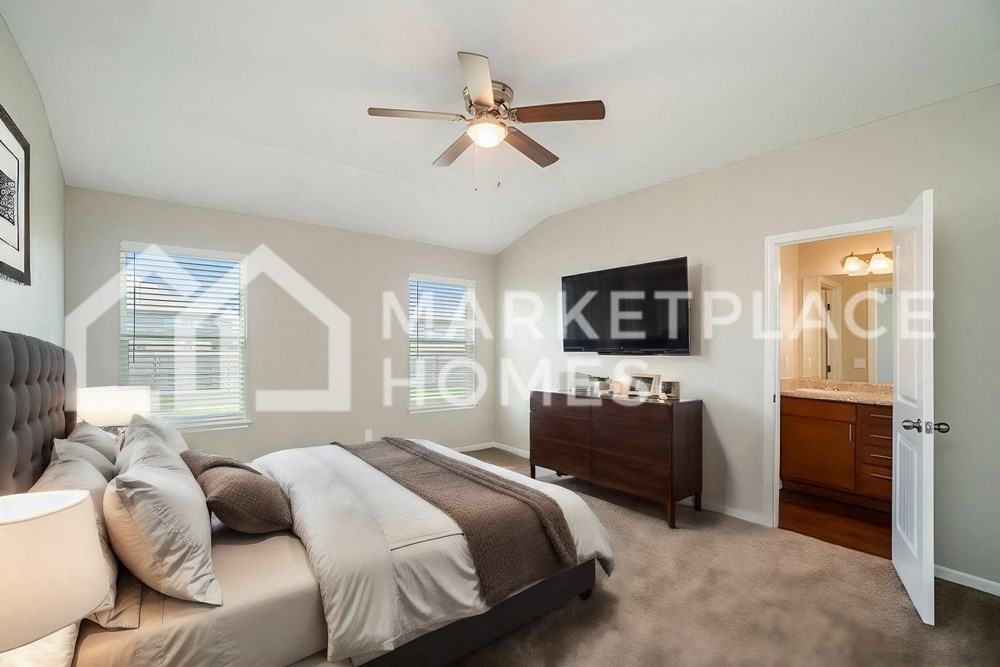 a bedroom with a large bed and a ceiling fan