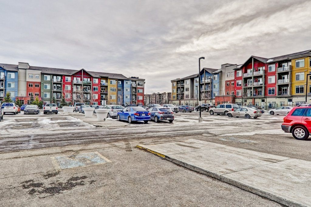 A parking lot with cars and apartment buildings in the background.