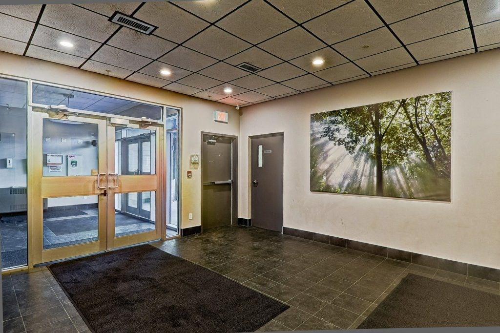 A hallway with a rug on the floor and a painting on the wall.