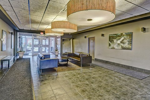 A spacious waiting area with a bench, a table, and a painting on the wall.