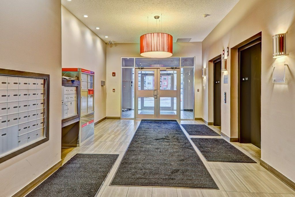 A hallway with a red chandelier and a black door.