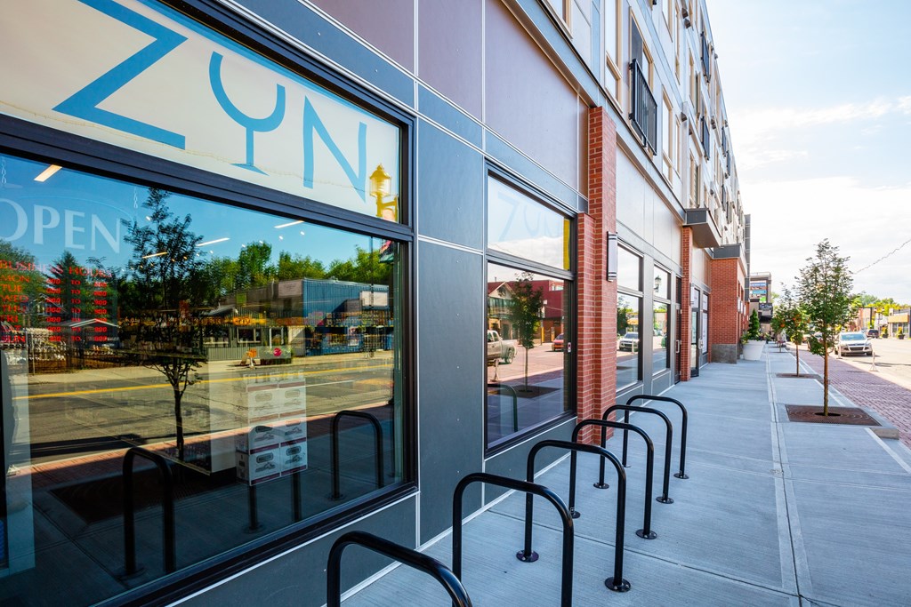 A row of black bike racks are outside a ZUN store.