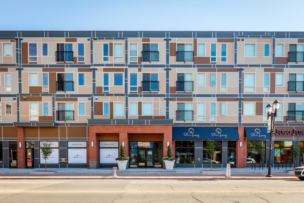 A street view of a building with a storefront on the ground floor.