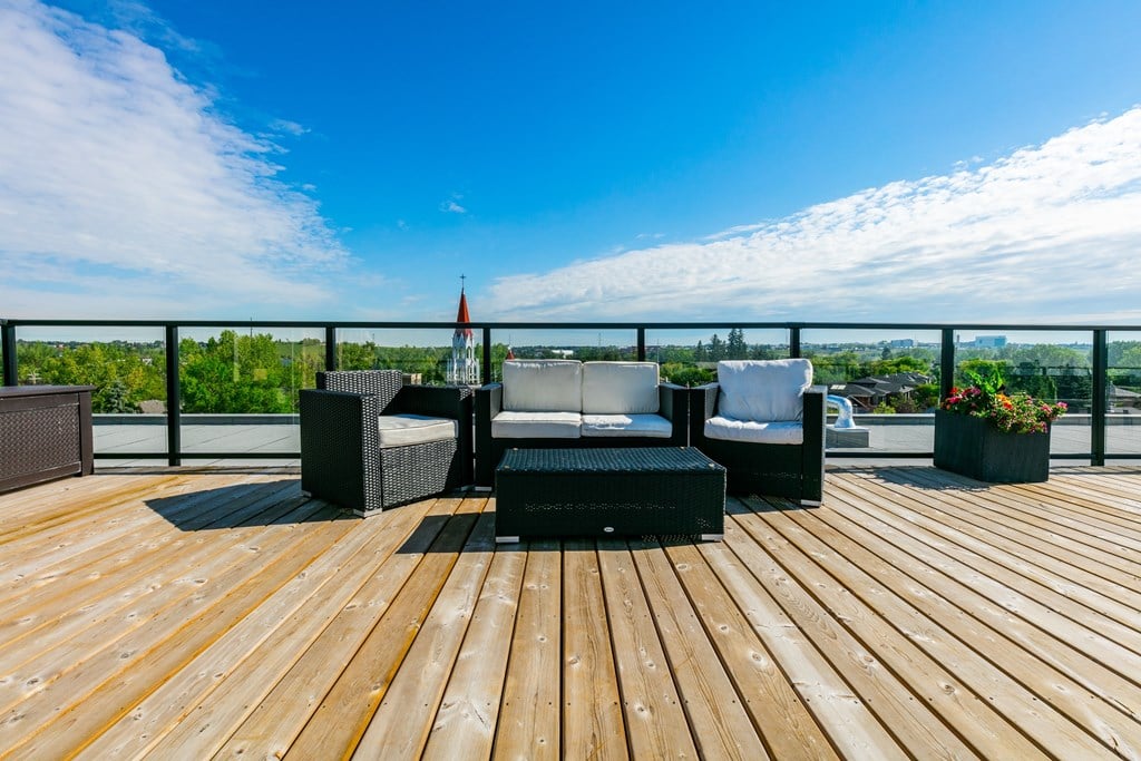 A wooden deck with a table and chairs overlooking a landscape.