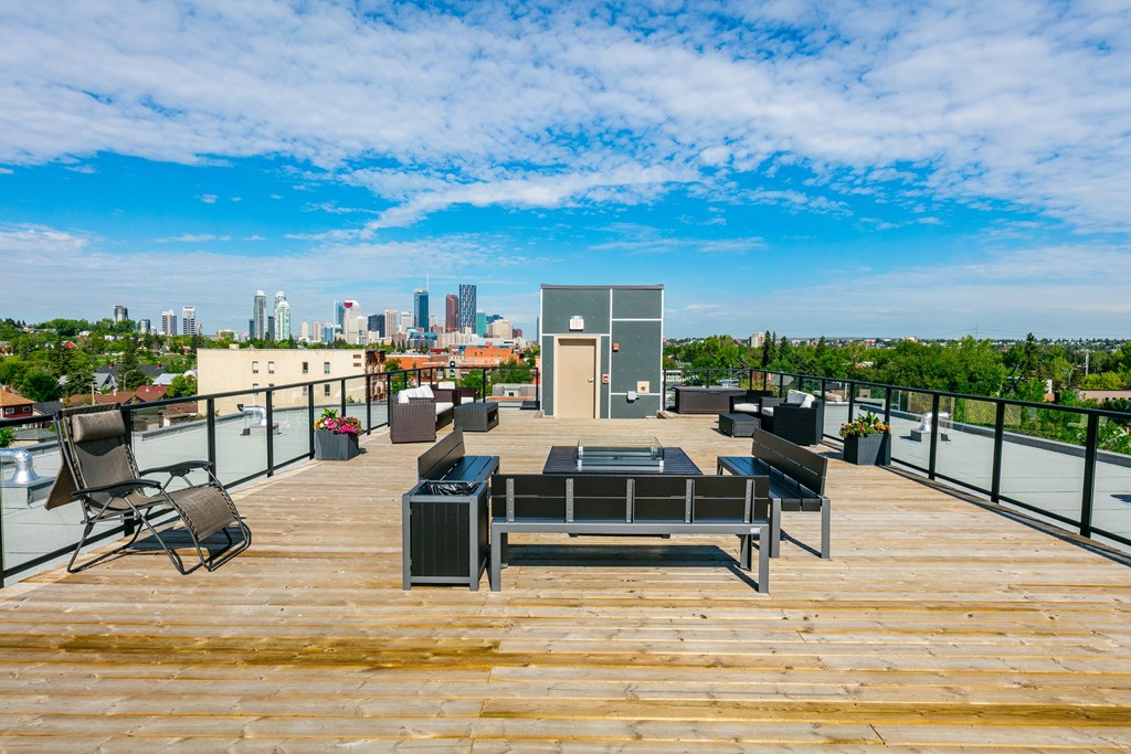 A wooden deck with a table and chairs overlooking a city skyline.