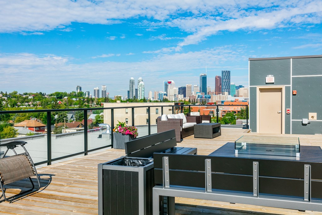 A balcony with a table and chairs overlooking a city skyline.