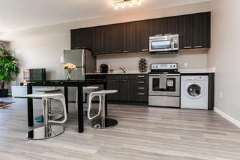 A modern kitchen with a black table and chairs.