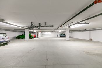 A spacious, empty parking garage with a concrete floor and white walls.
