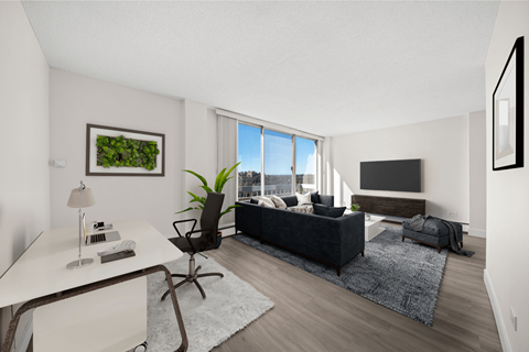 a living room with a black couch and a large window