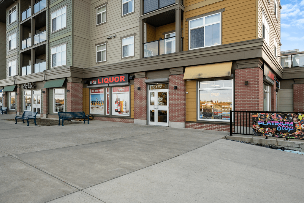 an empty sidewalk in front of a large apartment building