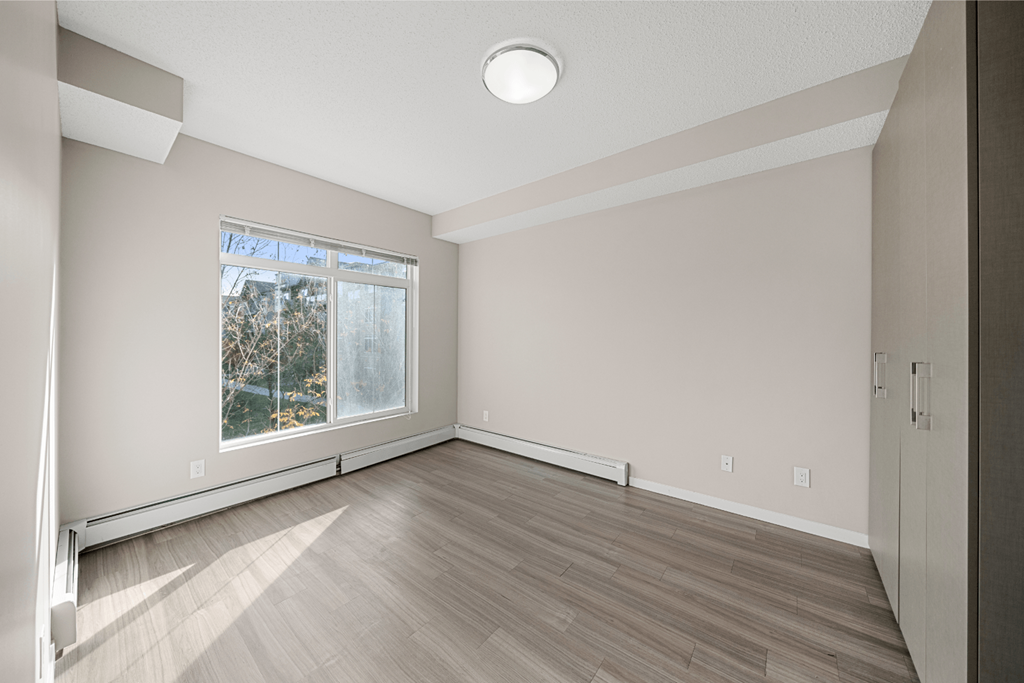 an empty room with wood floors and a window