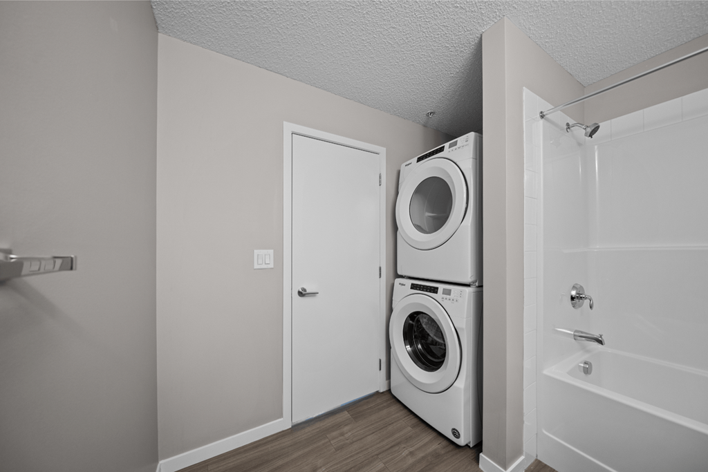 the living room has a washer and dryer and a door to the bathroom