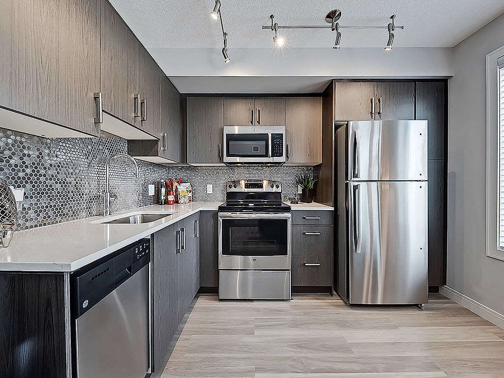 A modern kitchen with stainless steel appliances and wooden cabinets.