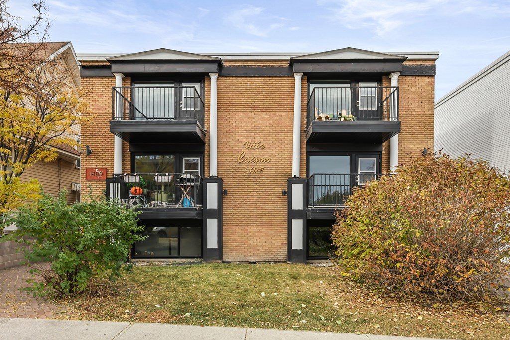 A brick building with two balconies in front of it.