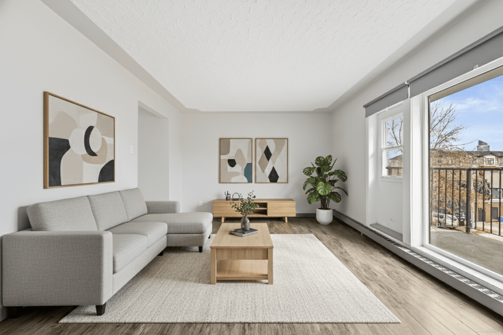 A living room with a grey sofa, a wooden coffee table, and two framed artworks on the wall.