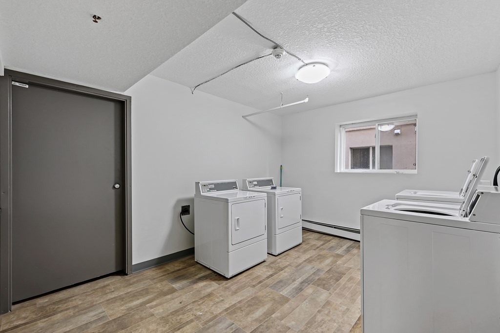 A room with a washing machine and a dryer.