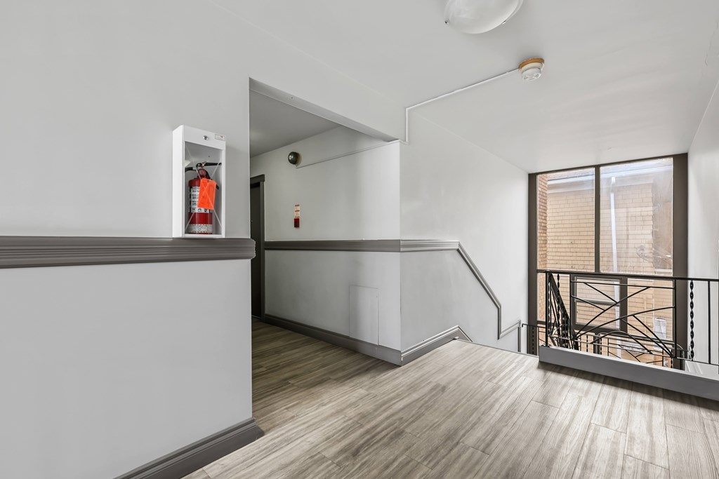 A white wall with a fire extinguisher on it.