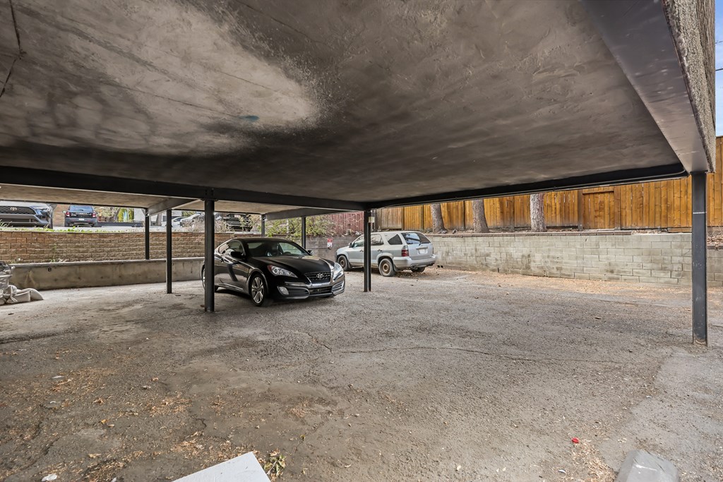 A carport with a black car parked inside.