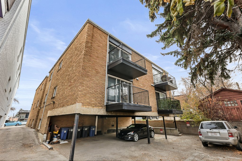 A modern two-story apartment building with a balcony on the second floor.