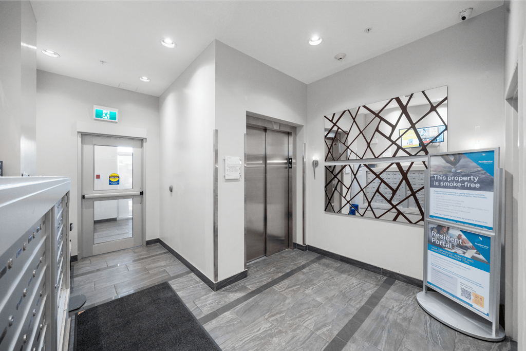 a corridor with a door to a bathroom and a hallway with elevators