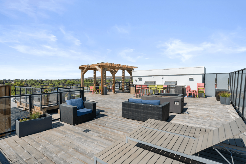 a rooftop patio with wooden furniture and a wooden gazebo