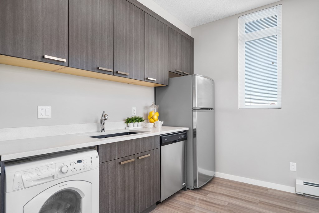a kitchen with a washing machine and a refrigerator