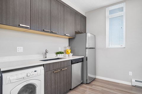 a kitchen with a washing machine and a refrigerator