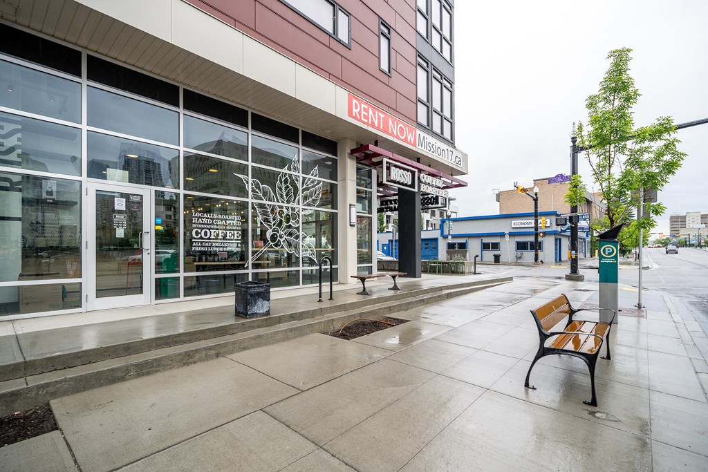 a bench on a sidewalk in front of a building on a city street