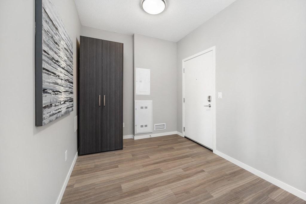 a white room with a wooden floor and a large wooden door