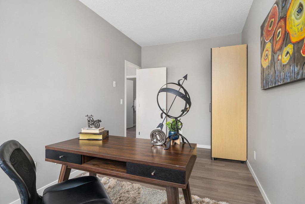 a living room with a desk and a door to a hallway