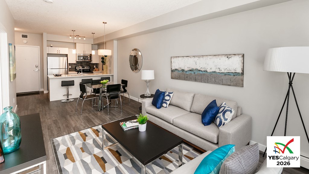 A living room with a couch, coffee table, and a painting on the wall.