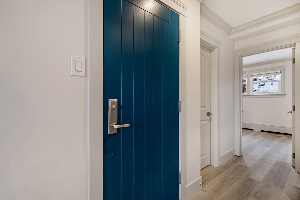 a blue door in a room with white walls and wood floors