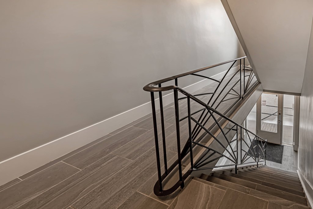 a stairwell in a home with white walls and wood floors
