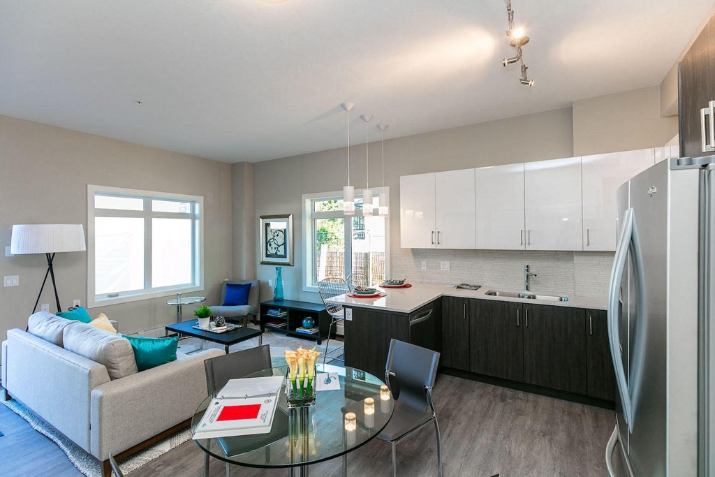 a living room and kitchen with a glass table