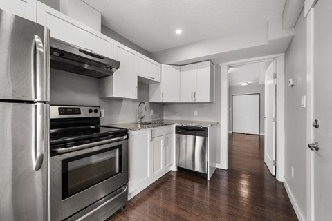 a kitchen with stainless steel appliances and white cabinets