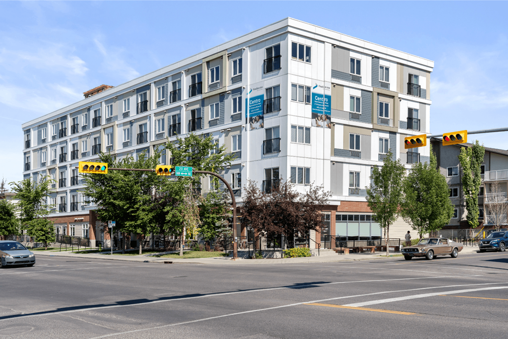 a white apartment building on the corner of a city street