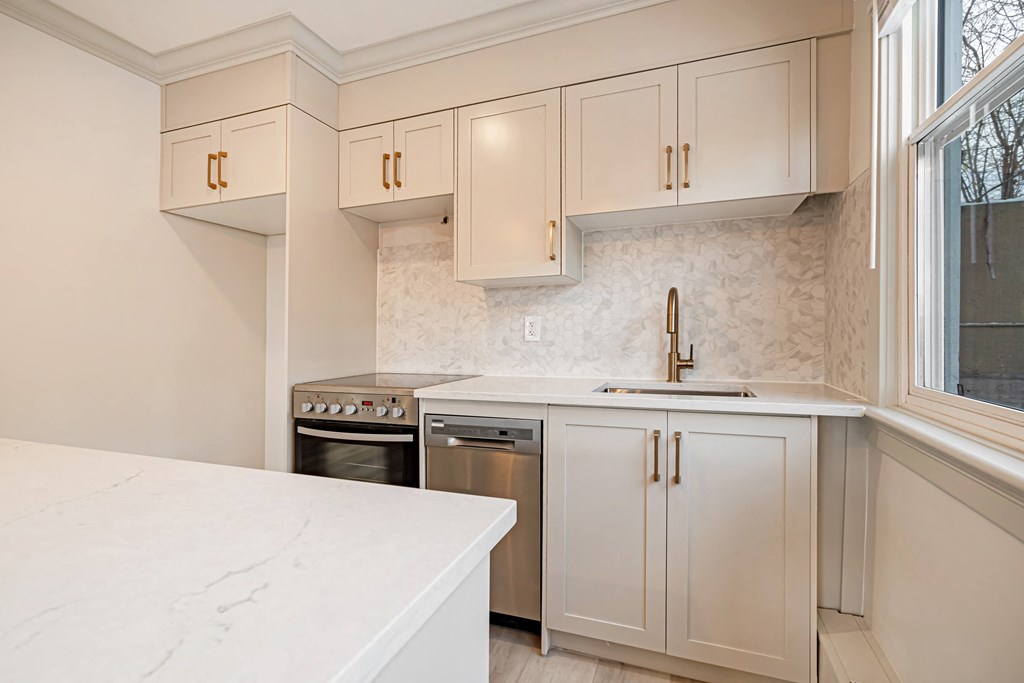 a kitchen with white cabinets and stainless steel appliances