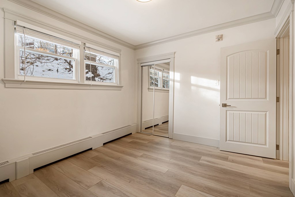 a living room with white walls and a white door and window