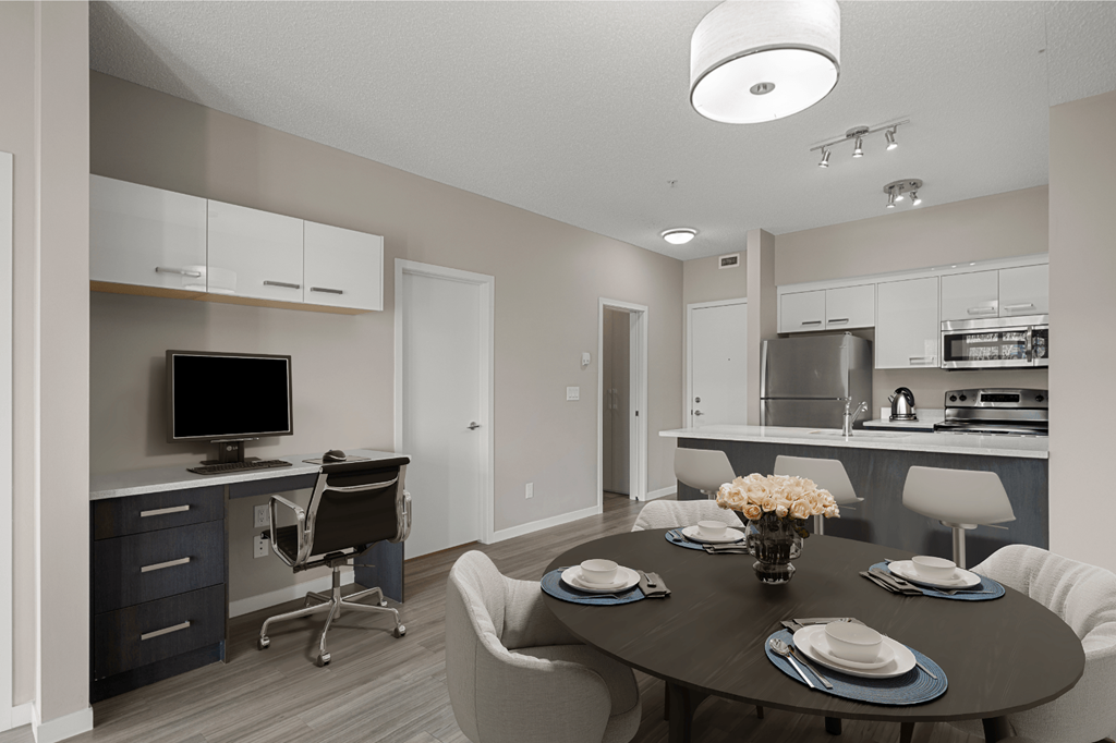 a dining room and kitchen with a table and chairs and a tv