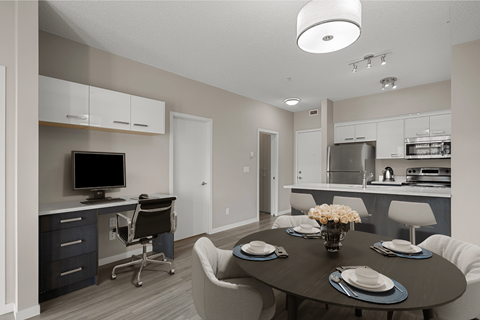 a dining room and kitchen with a table and chairs and a tv