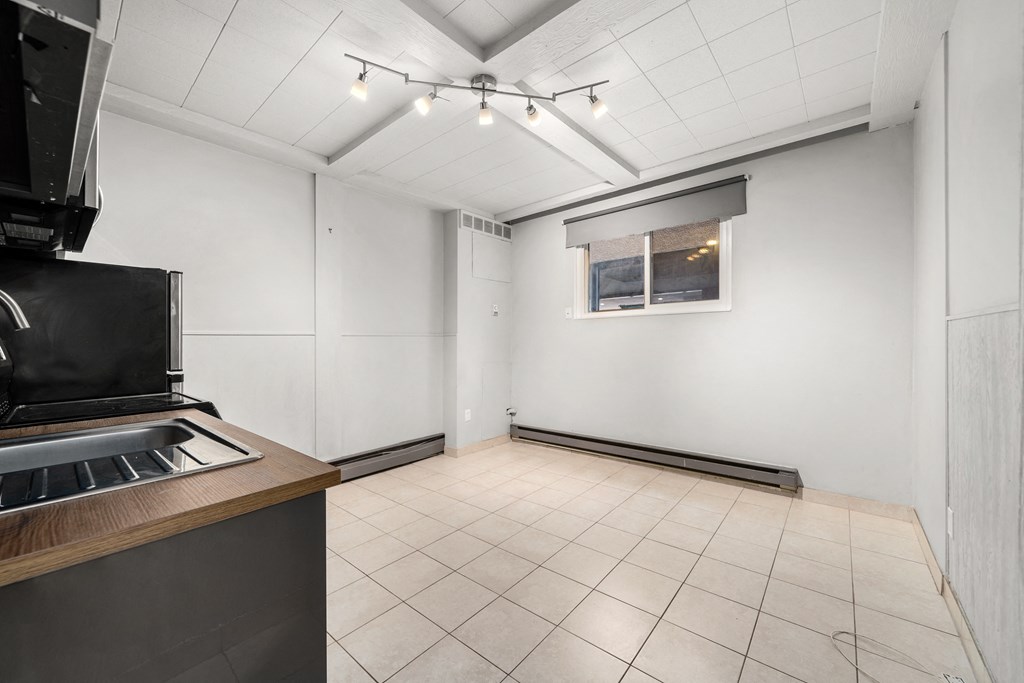 the living room of an empty house with a stove and a window