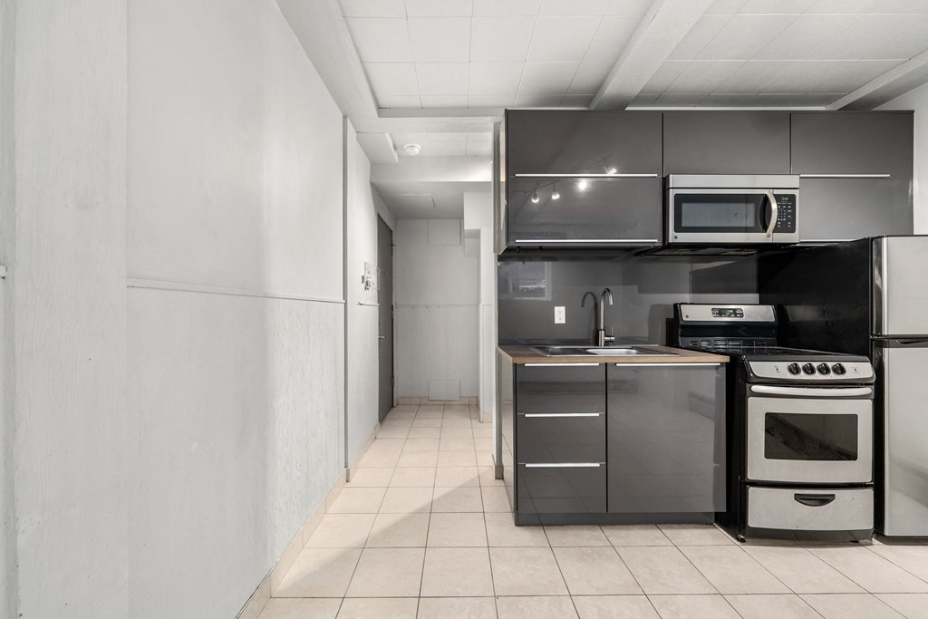 a kitchen with a stove and a refrigerator and a sink