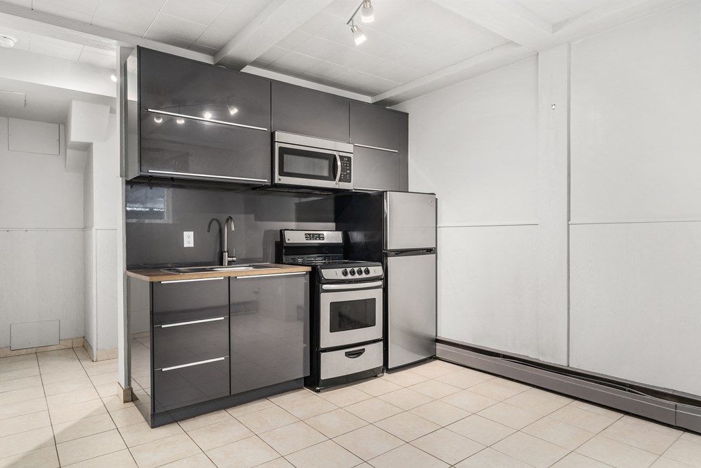 a kitchen with a stove and a refrigerator and a microwave