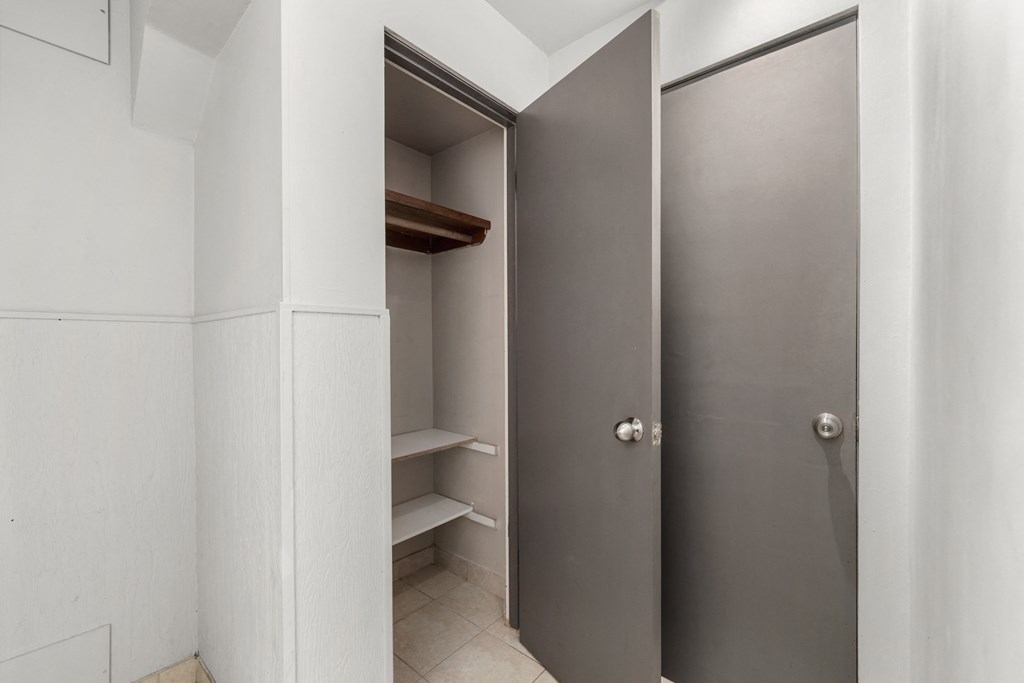 a walk in closet in a bathroom with a metal door