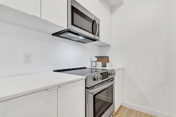 A modern kitchen with a stainless steel oven and microwave.