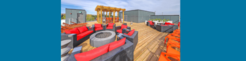 A wooden deck with red and black seating.