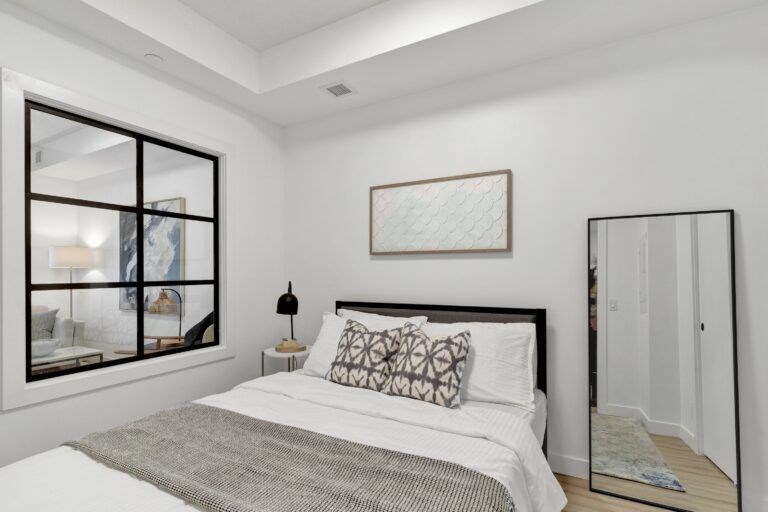 A bedroom with a large bed and a large mirror.