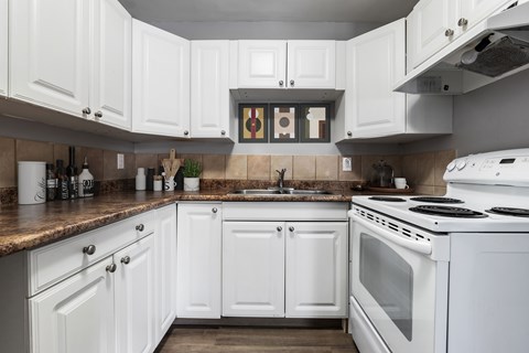 A kitchen with white cabinets and appliances.